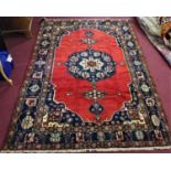 A Central Persian Bakhtiari carpet, central double pendent medallion on a rouge field, within