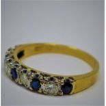 An 18ct yellow gold ring alternately set with 5 round faceted sapphires and 4 round brilliant-cut