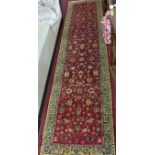 A Northwest Persian Sarouk runner with allover foliage and petal motifs on a rouge field within