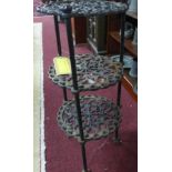 A cast metal three tier stand, with circular pierced floral tiers, on three paw feet, H.64cm