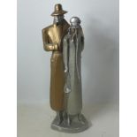 A cast plaster figure of a man and woman in trench coats, incised mark to base 'By Dustin Proding,
