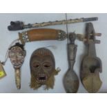 A small collecton of tribal art to include a mask, blow pipe, spoon, instrument, mask on bone