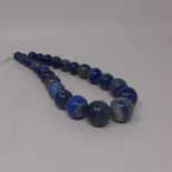 A large graduated necklace composed of 24 graduated natural lapis lazuli beads of polished,