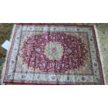 A Keshan style carpet, central floral medallion on a red ground, within floral border, 230 x 160cm