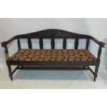 A 19th century oak bench, floral carved and splatted backrest, with carved dragon armrests, with