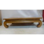 An Asian hardwood coffee table on thick carved legs, H: 33 x W: 120 x D: 68cm