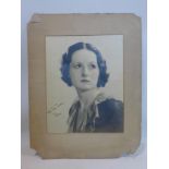 A large circa 1920's monochrome signed photograph of a female singer signed 'with best wishes,