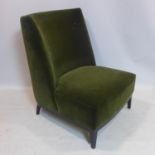 A large green velour upholstered chair, on ebonised square tapered feet