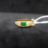 An 18ct yellow gold Colombian emerald and diamond ring set to the centre with a square, stepped-
