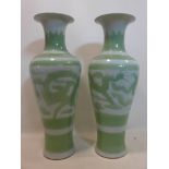 A large pair of Chinese vases decorated with dragons, in a green and white glaze, H.97cm