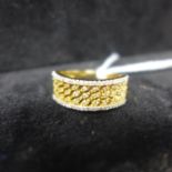 An 18ct yellow and white gold ring set to the centre with a pierced lattice design studded with