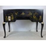 A black lacquered Chinoiserie desk, decorated with houses, figures, flowers and birds, having
