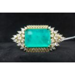 An 18ct yellow gold plated ring set to centre with a large stepped cut emerald framed by a white