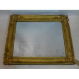 A late 19th / early 20th century giltwood mirror, with floral decoration, chips to frame, 92 x 79cm