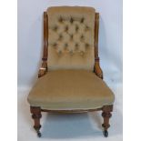 A Victorian mahogany chair with velour button back upholstery, raised on turned legs and castors