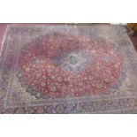 A large 20th century signed Kashan carpet, the central floral medallion surrounded by floral motifs,