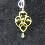 A 9ct yellow gold Art Nouveau pendant set with two faceted peridots to a yellow gold pendant loop,