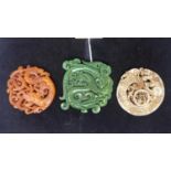 Three Chinese, hand carved hard-stone pendants/amulets in shades of dark orange, dark green and