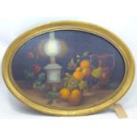 A 1970's oval oil on board depicting a still life of fruit, an oil lamp, flowers and a jug, signed