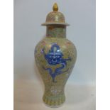 A large Chinese porcelain vase decorated with blue & white dragons surrounded by floral motifs, on a