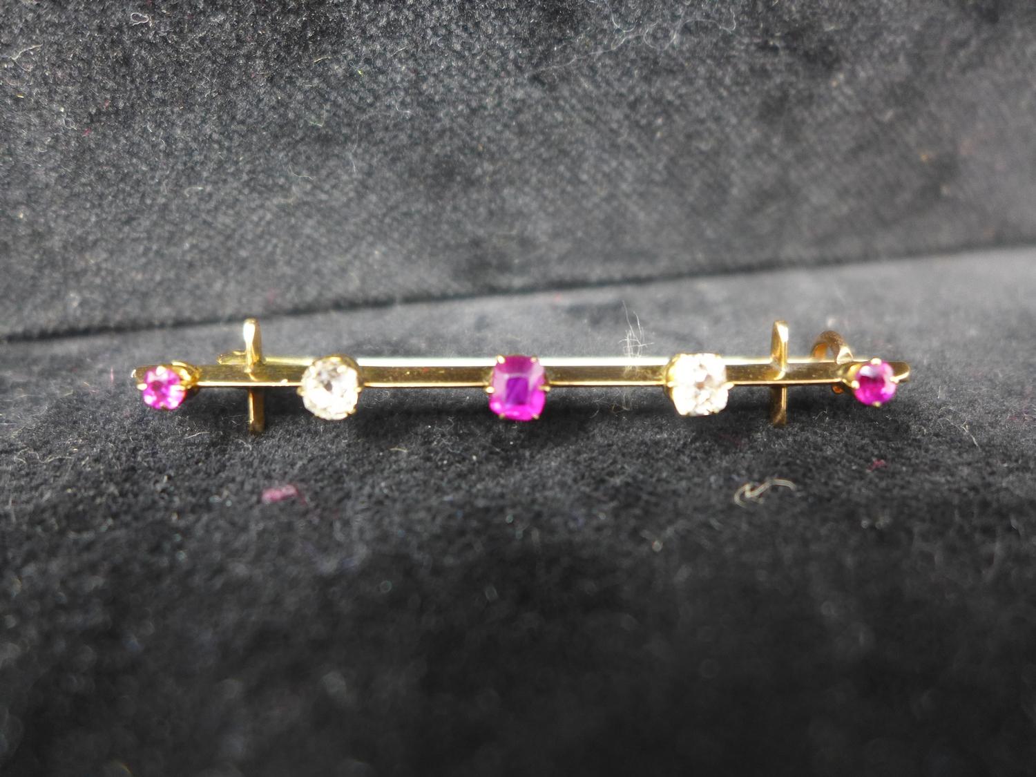 A 19th century, 18ct yellow gold bar brooch alternately set with three faceted rubies and two
