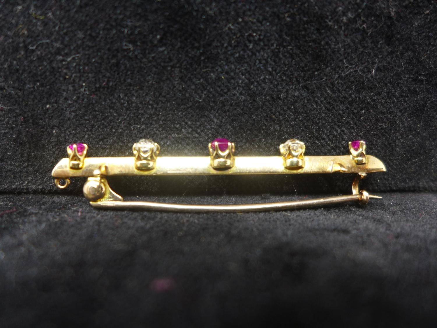 A 19th century, 18ct yellow gold bar brooch alternately set with three faceted rubies and two - Image 2 of 2