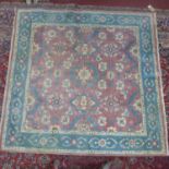 A 20th century square Indian Tabriz carpet, with floral motifs and swags, on a salmon pink ground,