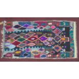 A vintage Moroccan Berber Azilal rug, with multi-coloured diamond motifs on a black ground, 220 x