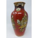 A 19th century Japanese satsuma vase, decorated with figures and flowers, on a red ground, bearing