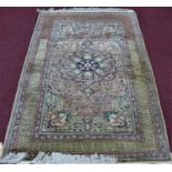 A Persian part silk rug, central floral medallion on a pink and cream ground with stylised bird
