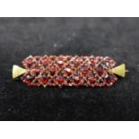 A 19th century, gilt metal and garnet-studded rectangular brooch, 1.5 x 5cm, 4.8g