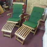 A pair of sun loungers with green cushions