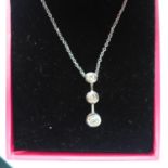 A boxed 18ct white gold pendant on chain, the pendant set with 3 graduated, round brilliant-cut