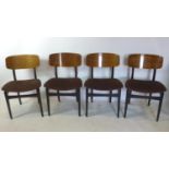 A set of four mid 20th century teak dining chairs, with black painted legs