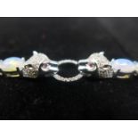 A sterling silver bracelet set with 17 oval Ethiopian opals and a white sapphire studded clasp in