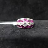 A platinum, brilliant-cut diamond and calibre cut ruby ring arranged over 5 rows and set to the