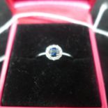 A boxed 18ct white gold faceted sapphire and brilliant-cut diamond cluster ring, Size: L, 1.8g