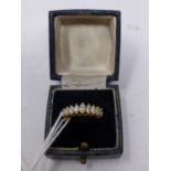 A boxed 18ct yellow gold ring set to the centre with a row of 9 graduated, marquise-cut diamonds,