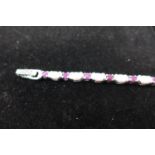 A sterling silver bracelet set with alternating faceted rubies and opalites, L: 18cm, 13.5g