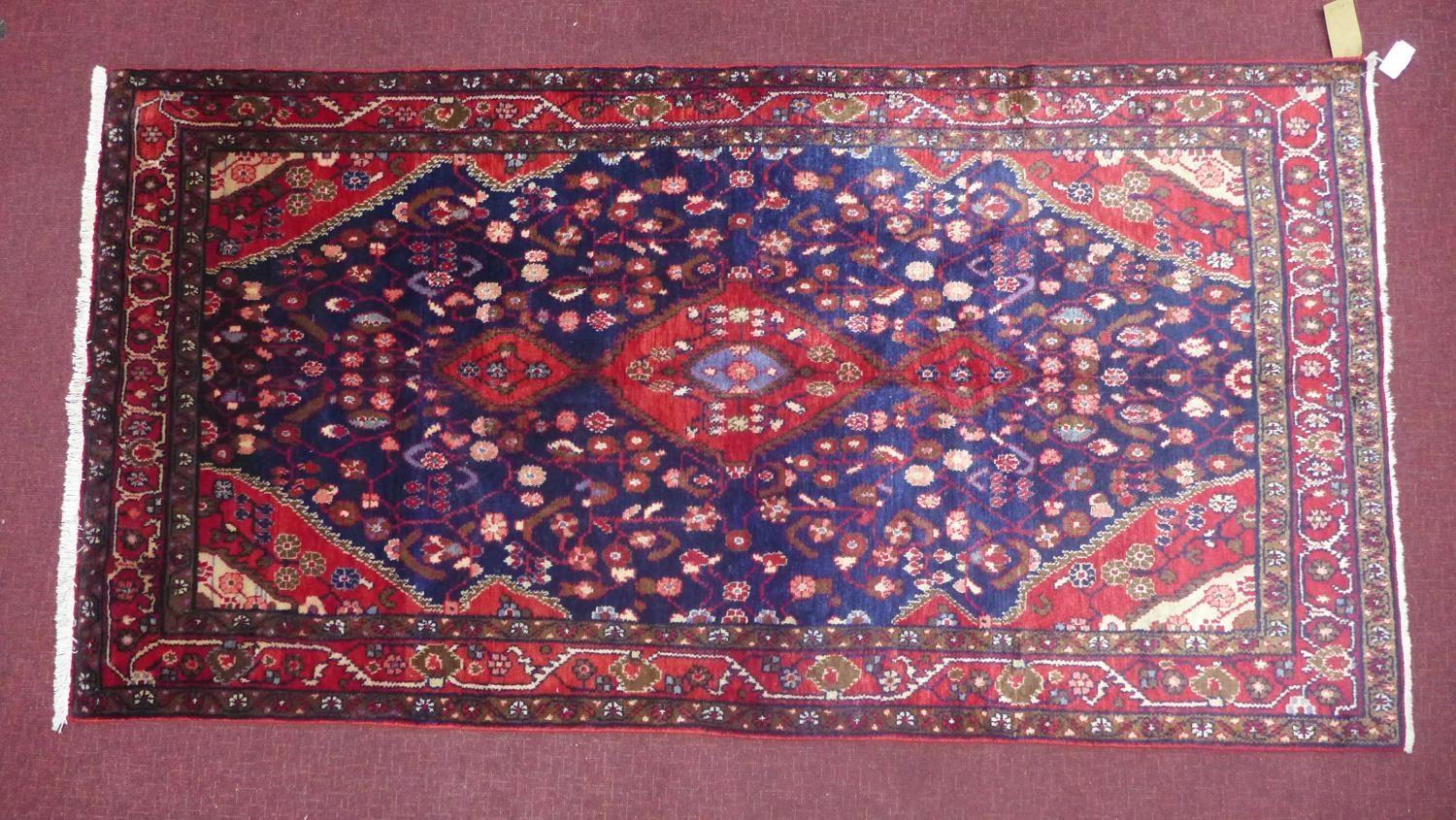 A North West Persian Nahawand rug, triple pole medallion with repeating petal motifs on a sapphire