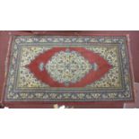 A Persian rug with central geometric floral medallion on a rouge field, within geometric floral