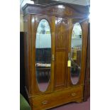 An early 20th century mahogany wardrobe, the arched pediment above two cupboard doors having