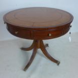 A Regency style mahogany drum table, with leather top and four drawers, raised on splayed legs and