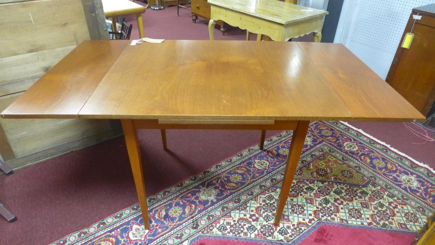 A 20th century teak extending dining table, with 2 leaves, raised on tapered legs, H.74 W.132 D.81cm