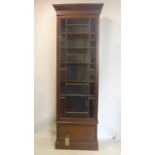 A Georgian style tall narrow bookcase, with glazed door above 1 drawer, raised on stepped base, H.