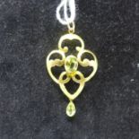 A 9ct yellow gold Art Nouveau pendant set with two faceted peridots to a yellow gold pendnat loop,