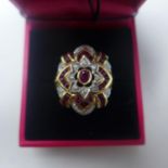 A boxed 14ct yellow gold, faceted ruby and brilliant-cut diamond cluster ring, Size: O, 7.3g