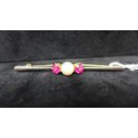 An 18ct yellow gold and platinum bar brooch set to the centre with a round natural opal flanked by