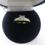 An 18ct yellow gold diamond solitaire ring (0.50 carats) to further diamond-set shoulders, Size: