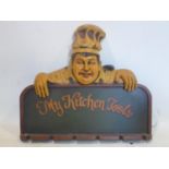 A hand-painted wood and plaster utensil rack adorned with a smiling chef to the top, 50 x 60cm